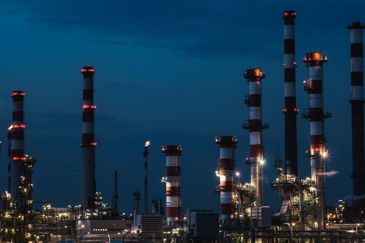 Refinery chimneys and process units lit at dusk